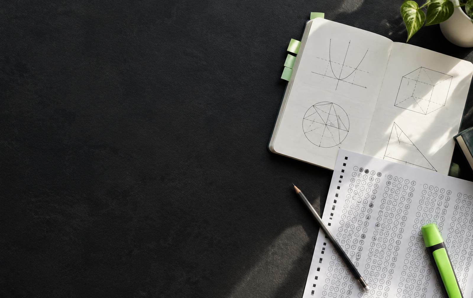 Caderno de estudos, folha de respostas e marca-texto sobre uma mesa